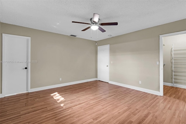 unfurnished bedroom with ceiling fan, light wood-type flooring, and a textured ceiling