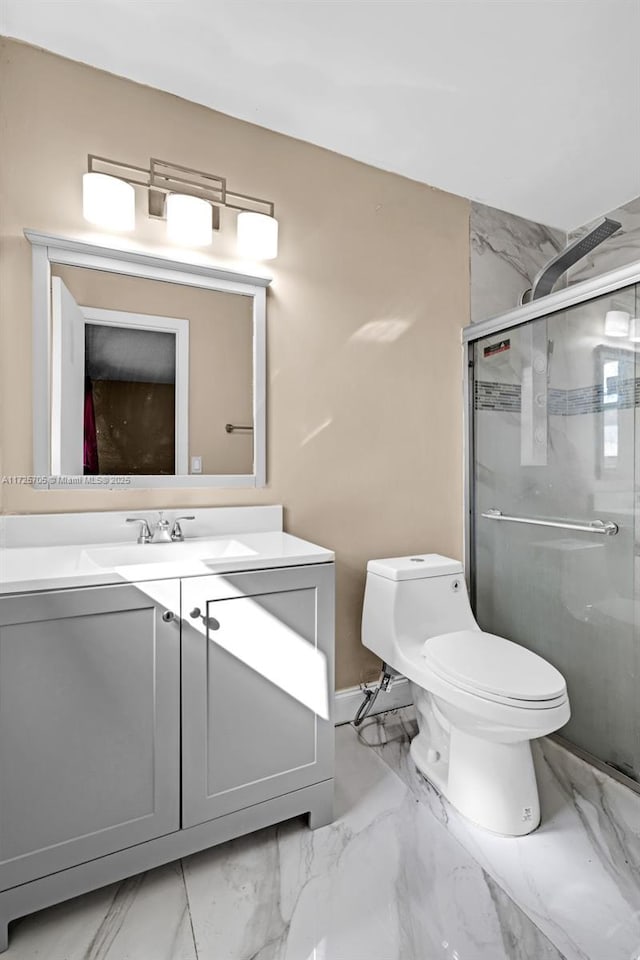 bathroom featuring toilet, vanity, and a shower with shower door