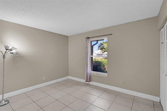 tiled spare room featuring a textured ceiling