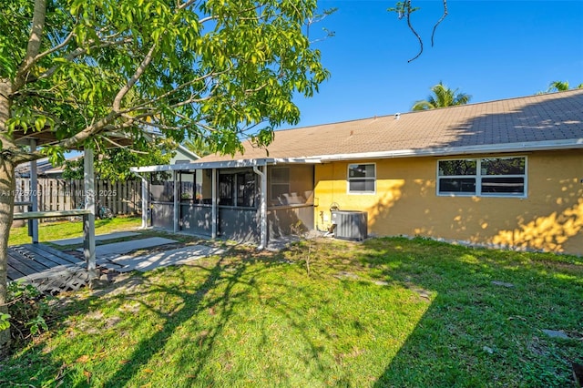 back of property with a lawn, cooling unit, and a sunroom