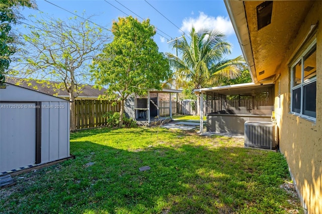 view of yard with central air condition unit and a storage shed