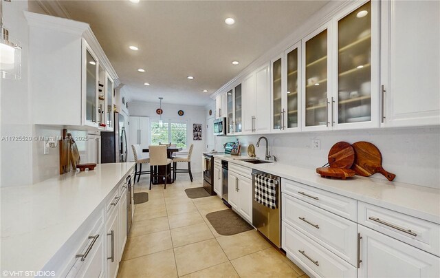 kitchen with light countertops, white cabinets, appliances with stainless steel finishes, and a sink