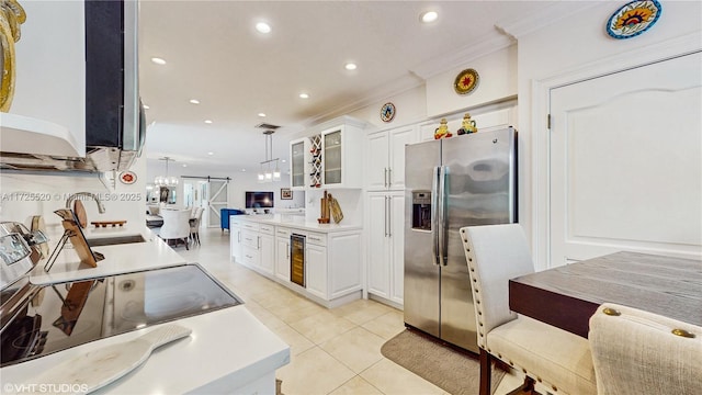 kitchen featuring light tile patterned floors, ornamental molding, glass insert cabinets, white cabinetry, and stainless steel fridge