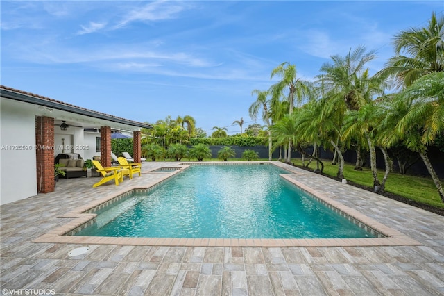 outdoor pool with a patio area and a ceiling fan