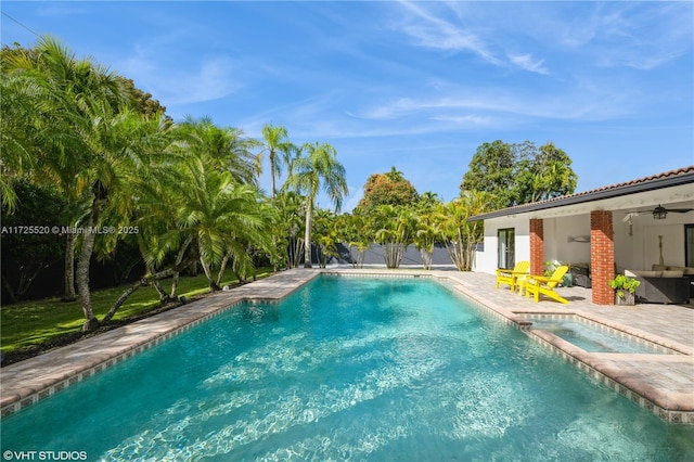 view of pool with ceiling fan, a pool with connected hot tub, and a patio