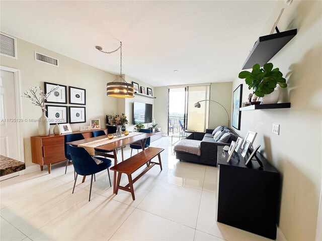 tiled dining space featuring an inviting chandelier and expansive windows