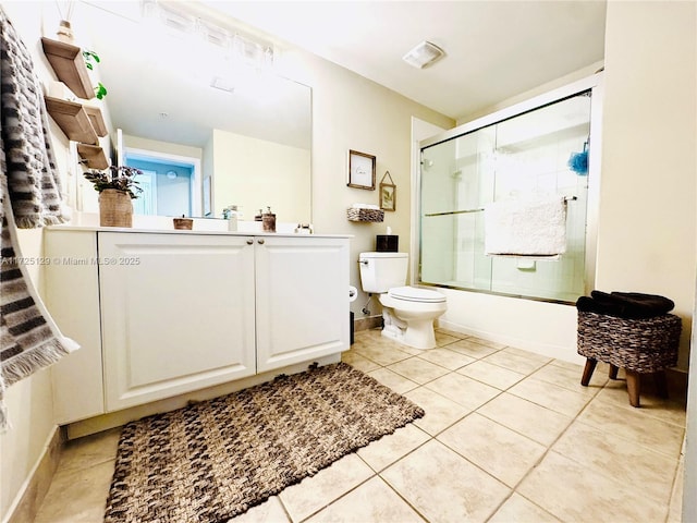 bathroom featuring toilet, enclosed tub / shower combo, vanity, baseboards, and tile patterned floors