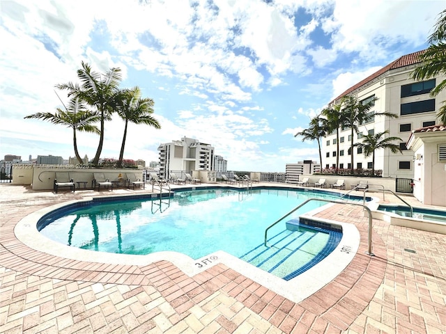 pool featuring a hot tub and a patio