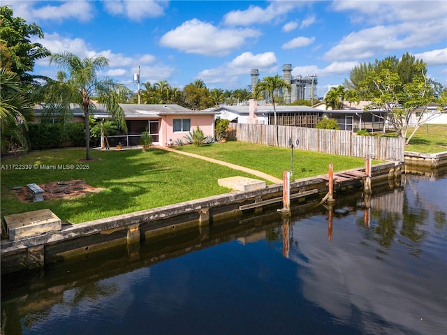 view of dock with a water view and a lawn