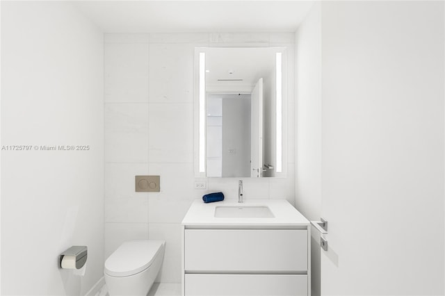 bathroom featuring tile walls, vanity, and toilet