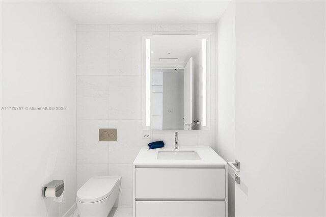 300 Biscayne Blvd Way Unit 2505, Miami, FL 33131 - half bathroom featuring toilet, vanity, and tile walls
