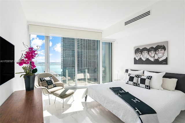 bedroom featuring floor to ceiling windows and a water view