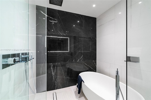 bathroom with tile walls, tile patterned floors, and shower with separate bathtub