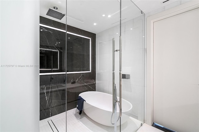 bathroom with tile patterned flooring, tile walls, and separate shower and tub