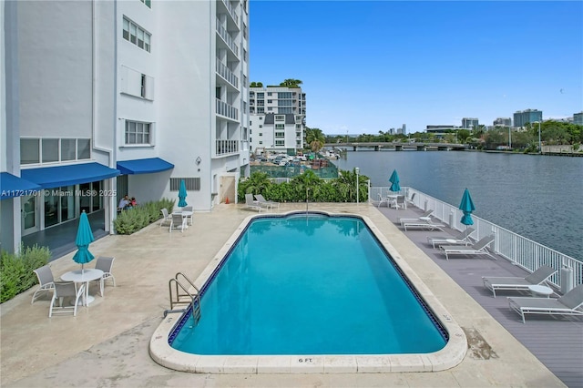 view of swimming pool with a water view and a patio area