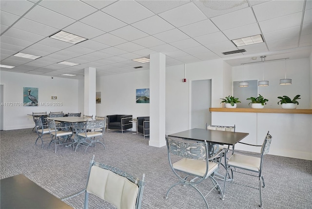 dining area featuring a paneled ceiling and carpet floors