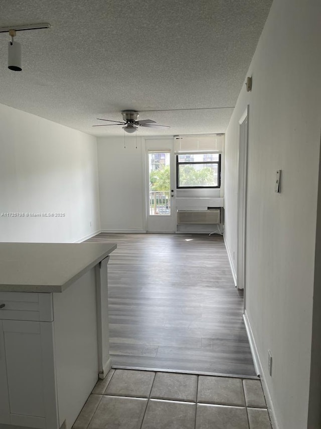 interior space with a textured ceiling and ceiling fan