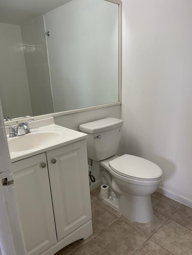 bathroom featuring tile patterned flooring, vanity, and toilet