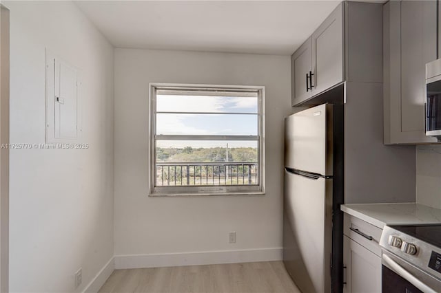 kitchen featuring stainless steel appliances, gray cabinets, light hardwood / wood-style floors, and a healthy amount of sunlight