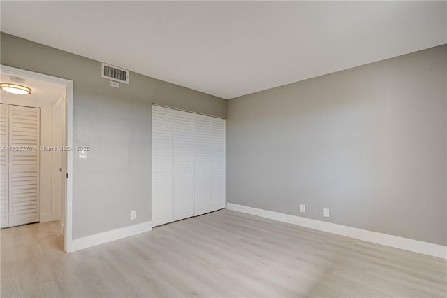 unfurnished bedroom with light hardwood / wood-style flooring and a closet