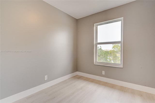 spare room featuring light wood-type flooring and a wealth of natural light