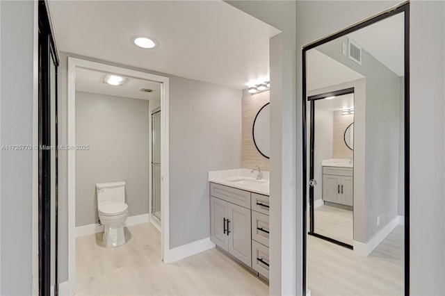 bathroom with toilet, hardwood / wood-style flooring, and vanity