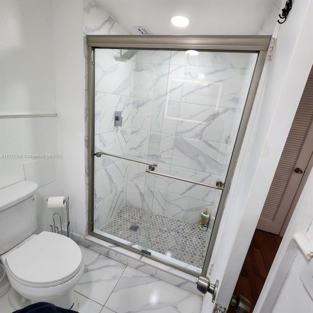 bathroom featuring toilet and walk in shower