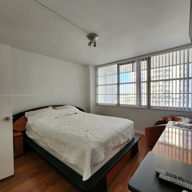 bedroom with dark hardwood / wood-style flooring