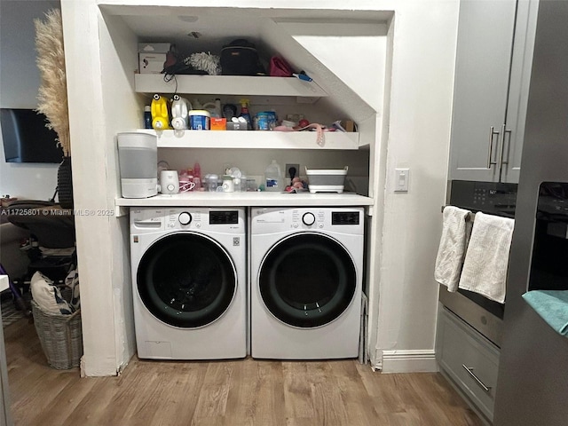 laundry room featuring washer and dryer and light hardwood / wood-style flooring