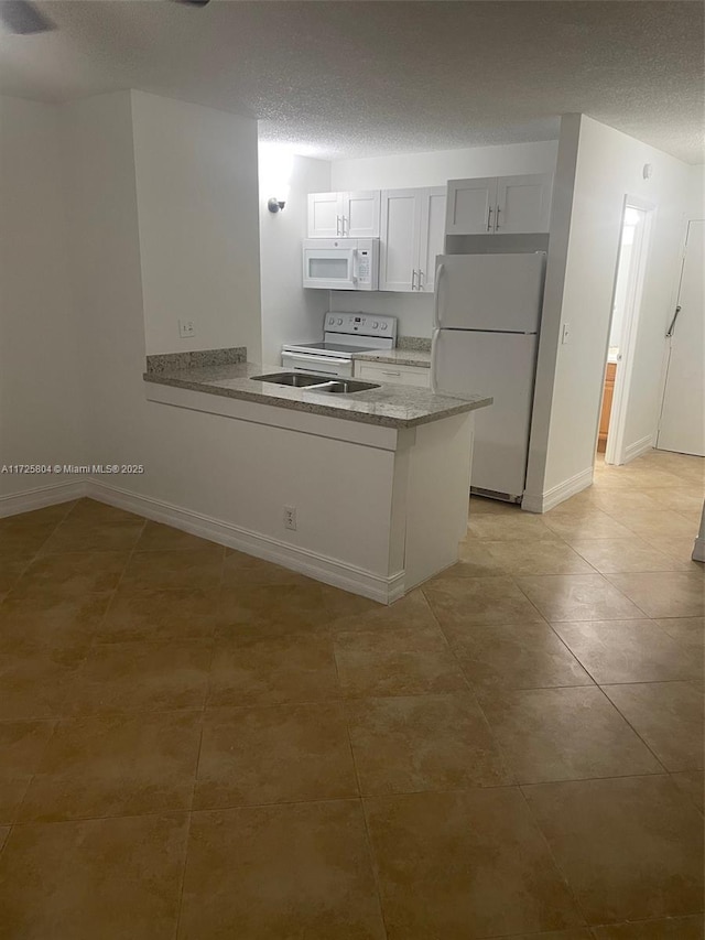 kitchen featuring a textured ceiling, white cabinetry, white appliances, light tile patterned floors, and kitchen peninsula