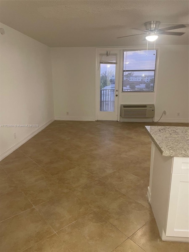 unfurnished living room featuring a textured ceiling, ceiling fan, and a wall mounted air conditioner