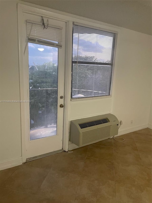 entryway with a wall mounted air conditioner and tile patterned floors