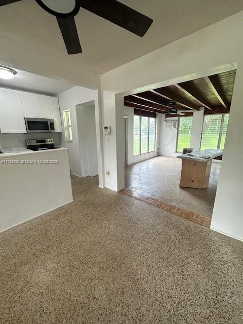 unfurnished living room with beam ceiling, ceiling fan, and wooden ceiling