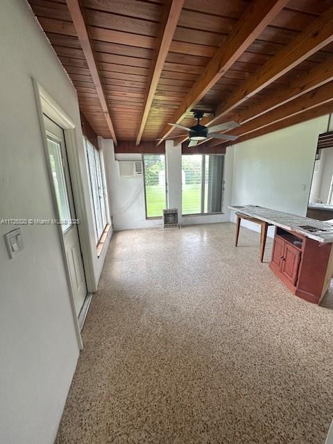 interior space featuring a wall mounted AC, beam ceiling, ceiling fan, and wooden ceiling