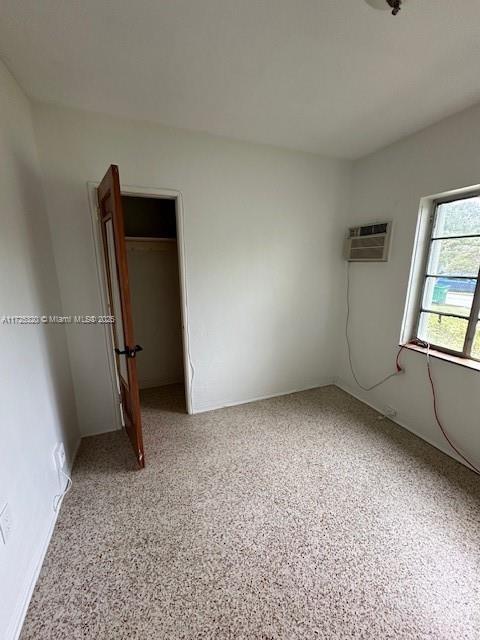 unfurnished bedroom with a wall mounted AC