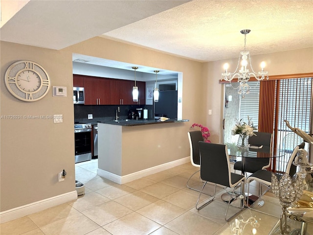 kitchen featuring an inviting chandelier, appliances with stainless steel finishes, light tile patterned floors, and tasteful backsplash