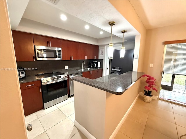 kitchen with decorative light fixtures, decorative backsplash, appliances with stainless steel finishes, light tile patterned flooring, and sink