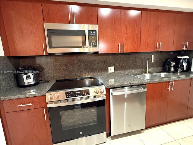kitchen featuring sink, light tile patterned floors, backsplash, and appliances with stainless steel finishes