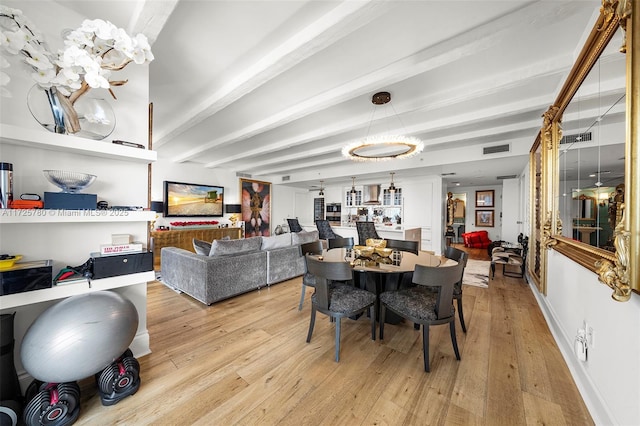 dining room featuring light wood-type flooring and beamed ceiling