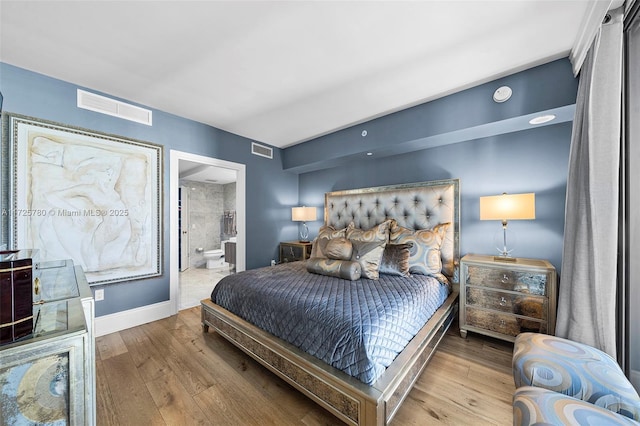 bedroom featuring connected bathroom and hardwood / wood-style floors