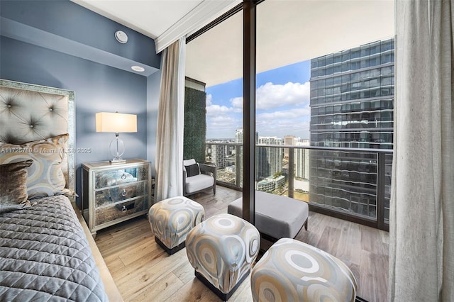 bedroom with hardwood / wood-style flooring and a wall of windows