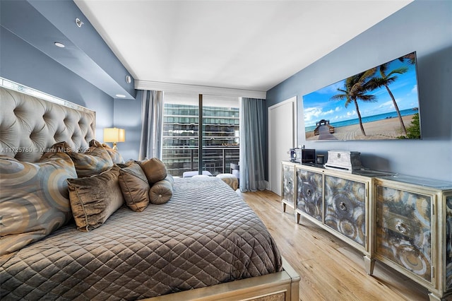 bedroom featuring expansive windows and light wood-type flooring