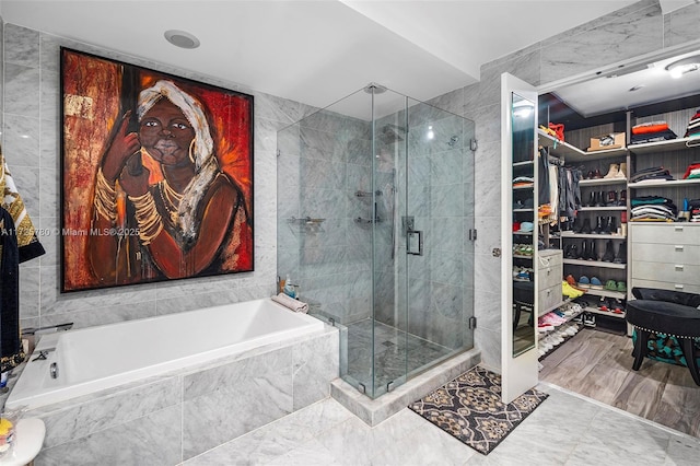 bathroom with independent shower and bath and tile walls