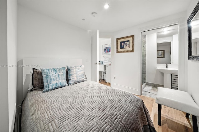 bedroom with ensuite bathroom and wood-type flooring