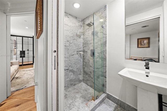 bathroom with a shower with shower door, sink, and wood-type flooring