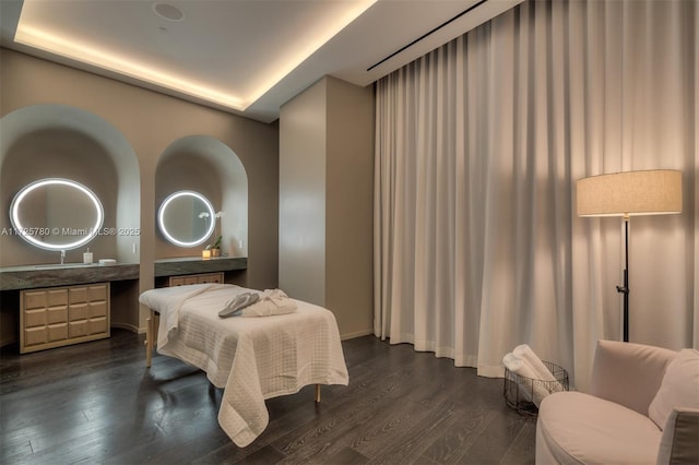 bedroom featuring dark wood-type flooring and a tray ceiling