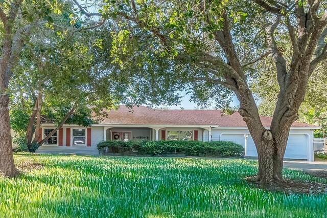 single story home with a garage and a front lawn