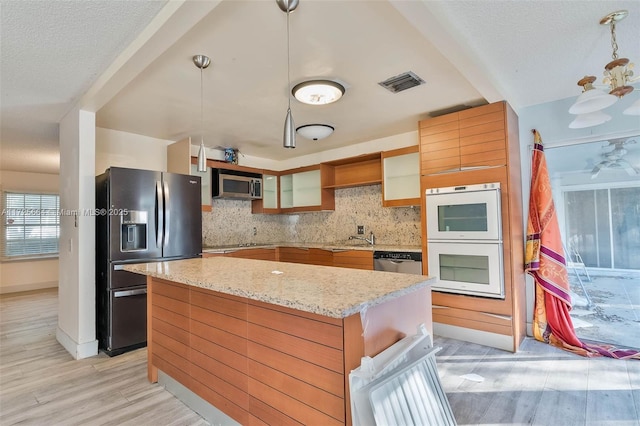 kitchen featuring open shelves, visible vents, light wood-style flooring, backsplash, and appliances with stainless steel finishes