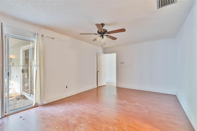 unfurnished room featuring visible vents, light wood-style flooring, ceiling fan, a textured ceiling, and baseboards