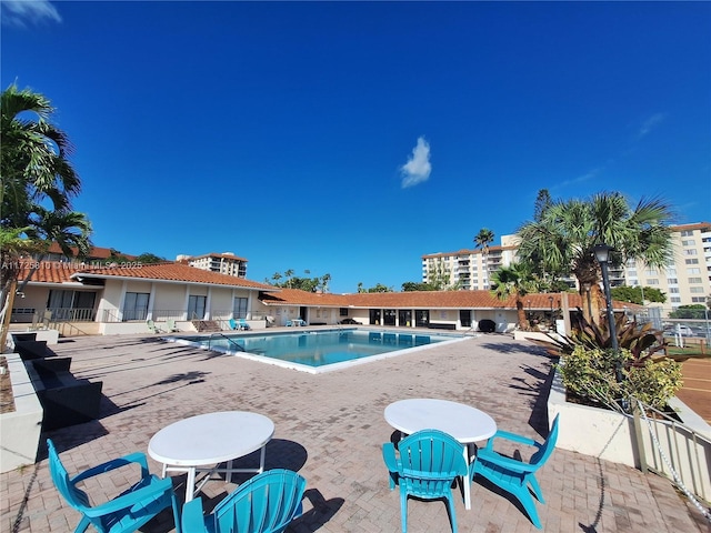 community pool featuring a patio and fence